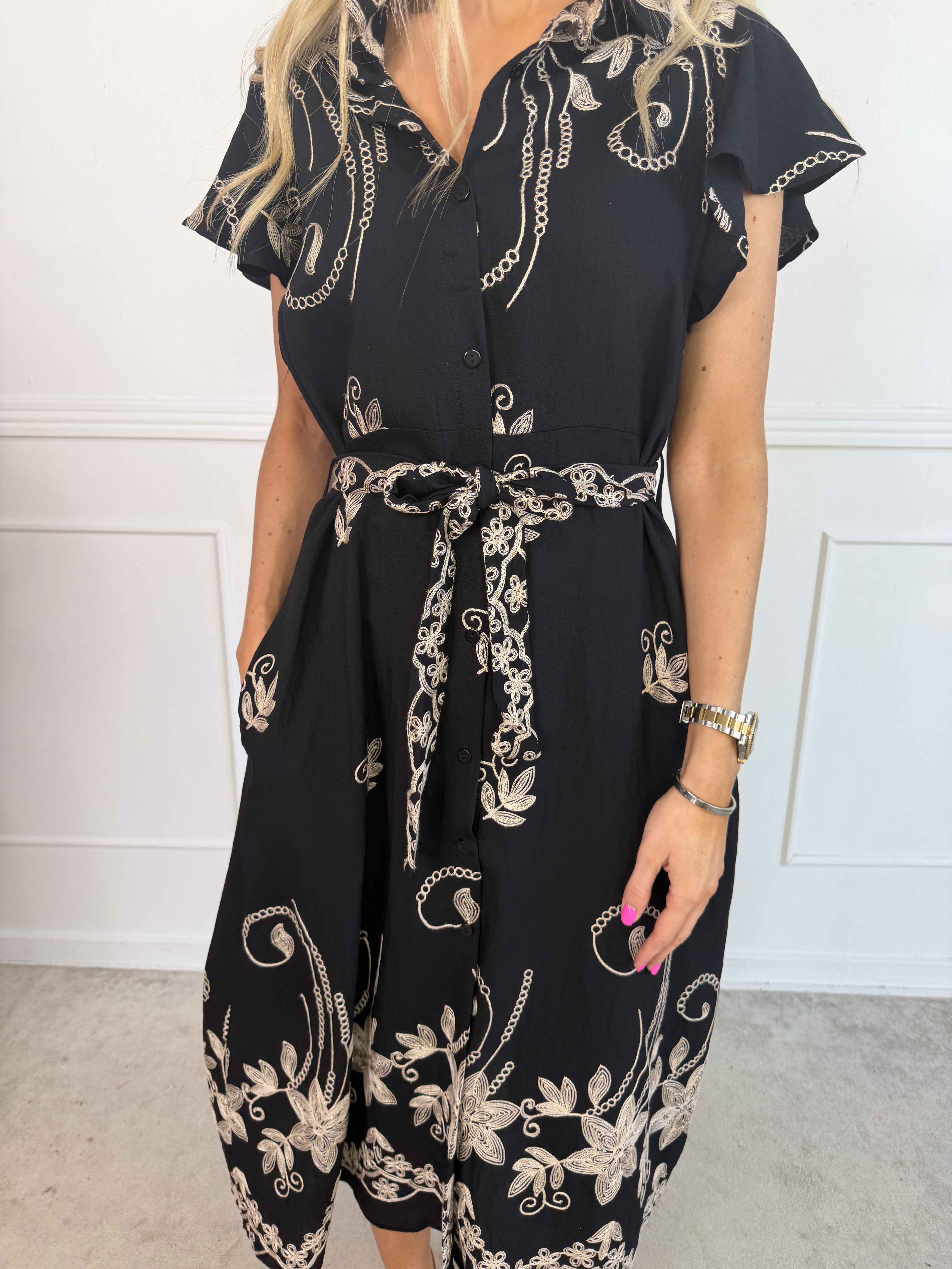 Marianne - Skjortekjole i viskose med broderede detaljer og flæseærmer.